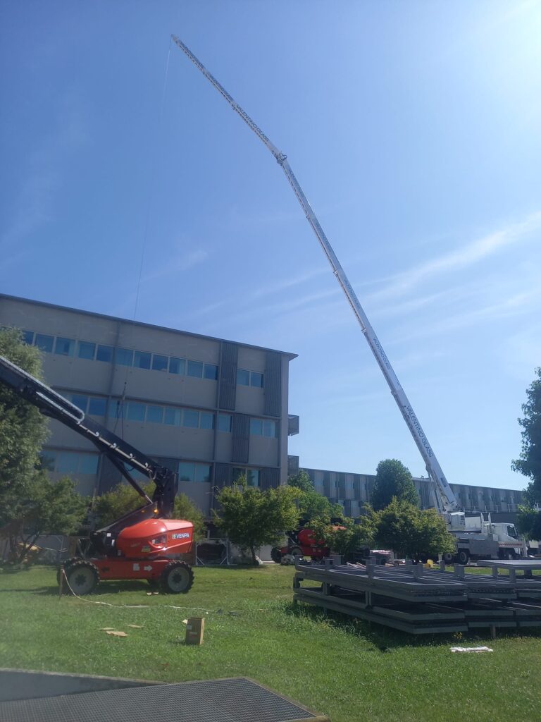 Gru con braccio di 60 metri solleva materiale per l'installazione su facciata aziendale