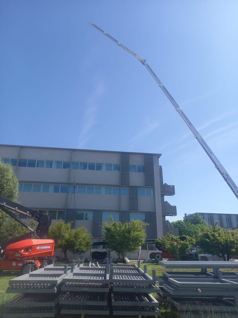 Sollevamento Materiale con gru di 60 metri per installazione pannelli su facciata